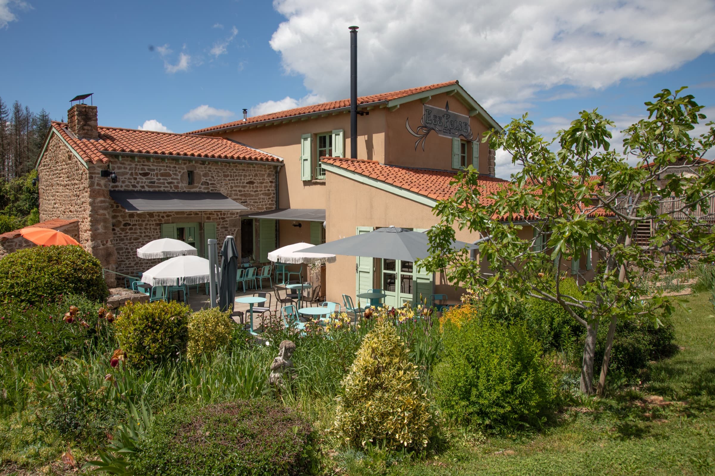 Bâtisse en pierre et terrasse du café-restaurant Ess'Folie à Chambles